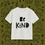 White t-shirt with 'Be Kind' text on a green background with black illustrations