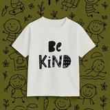White t-shirt with 'Be Kind' text on a green background with black illustrations