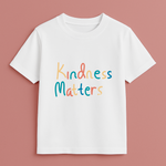 White t-shirt with 'Kindness Matters' text on a pink background