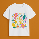 White t-shirt with colorful 'BE KIND' design on a brown background